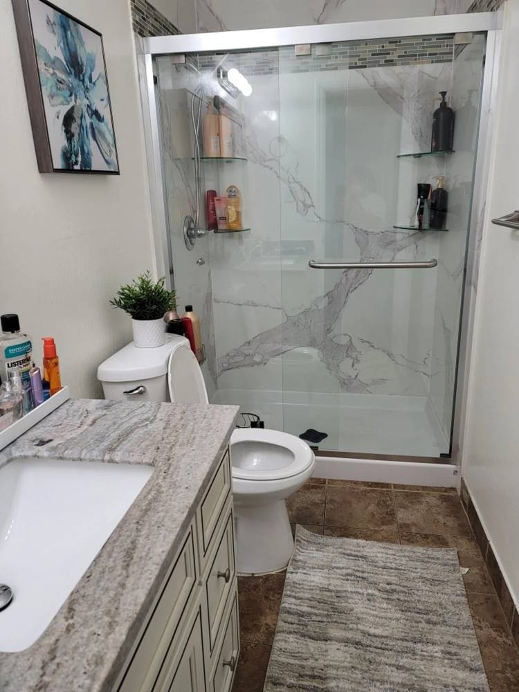 Clean, bright bathroom with a glass shower and polished vanity