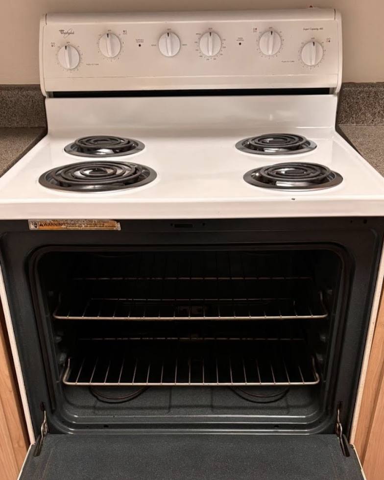 After: white stove with clean burners and oven
